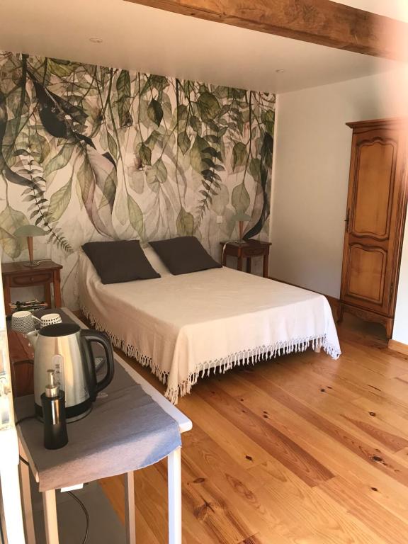 1 dormitorio con 1 cama y un mural en la pared en Chambre d'hôte aux Pivoines, en Nistos