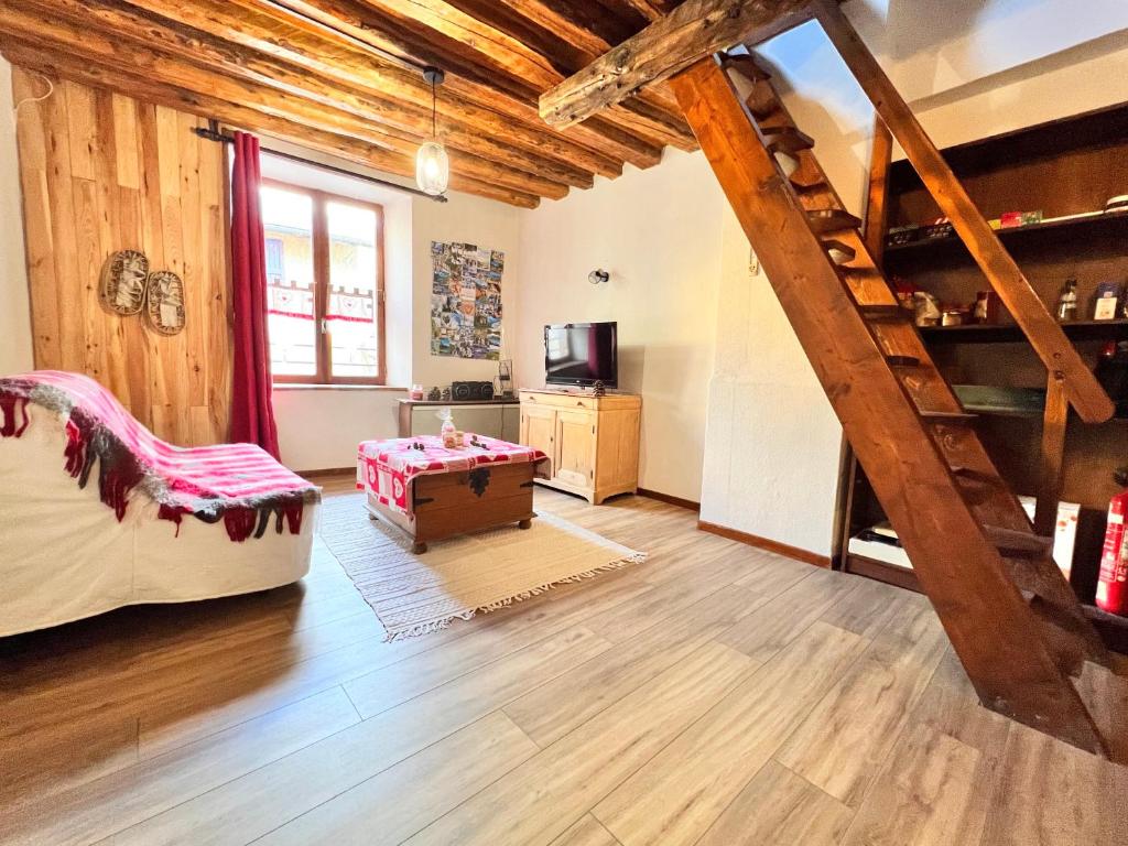 uma sala de estar com um tecto de madeira e uma escada em T2 au charme authentique em Briançon