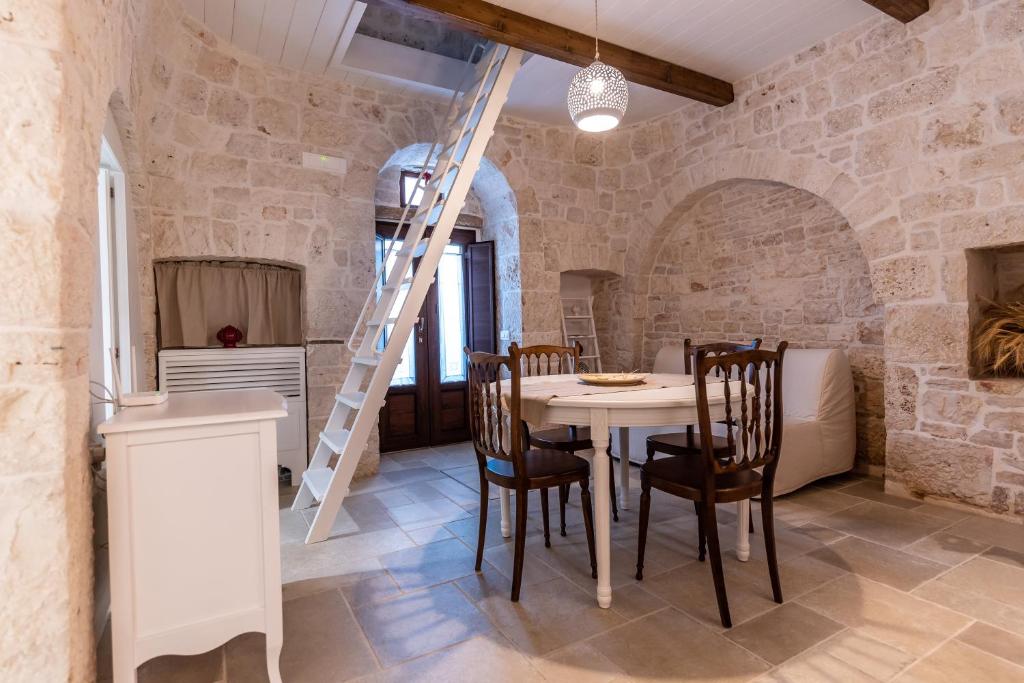 une cuisine et une salle à manger avec une table et des chaises dans l'établissement Il trullo del Guelfo, à Alberobello 21 autres photos