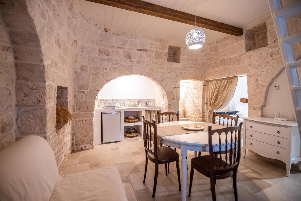 une cuisine et une salle à manger avec une table et des chaises dans l'établissement Il trullo del Guelfo, à Alberobello
