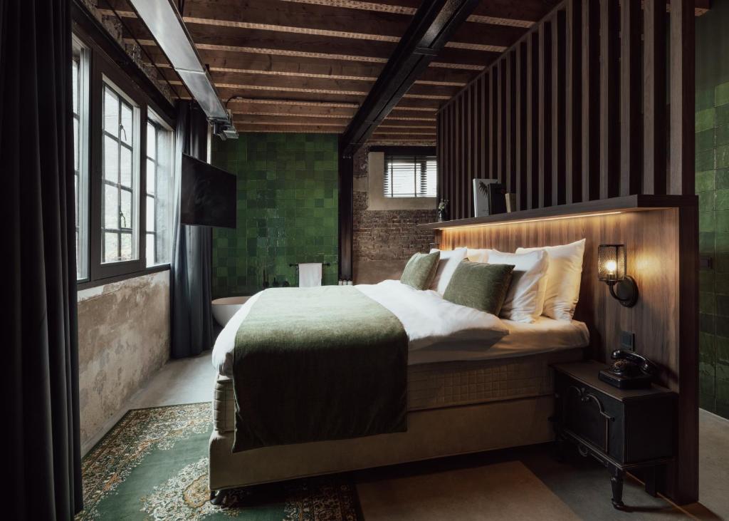 a bedroom with a large bed and a bathroom at Cousins Boutique Hotel in Maastricht