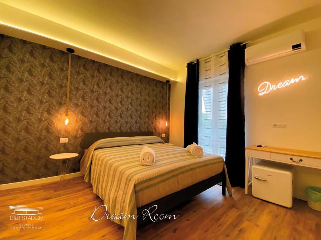 a bedroom with a bed and a sign on the wall at b&b Stadium room & suite in Crotone