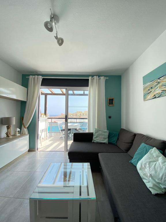 コスタ・デ・アンティグアにあるAmaya Ocean View Apartmentのリビングルーム(ソファ、ガラステーブル付)