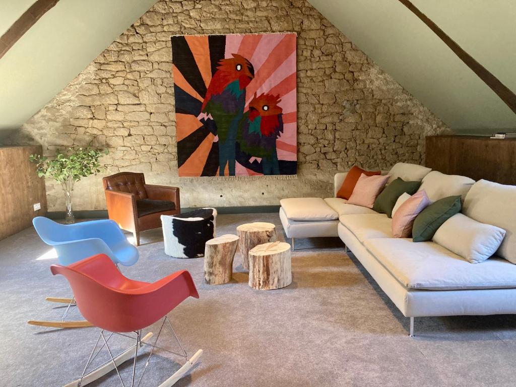 Locmalo的住宿－Encore une fois, La grande maison，客厅配有沙发、桌子和绘画作品
