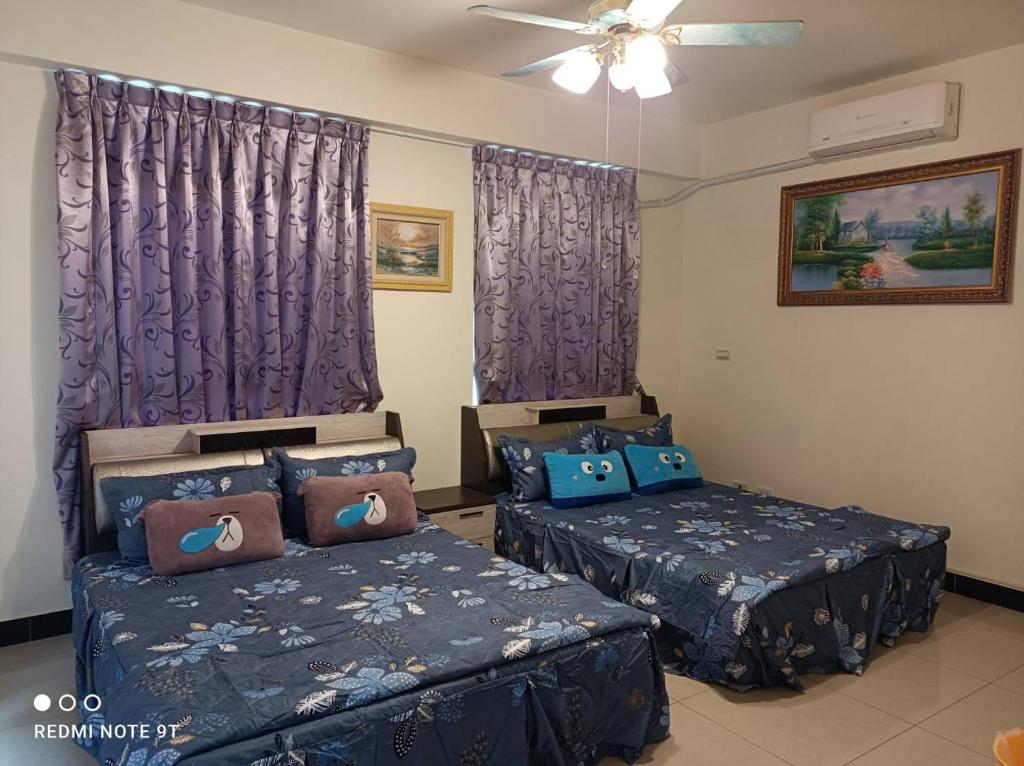 een slaapkamer met 2 bedden en paarse gordijnen bij 988 Ancient House B&B in Jincheng