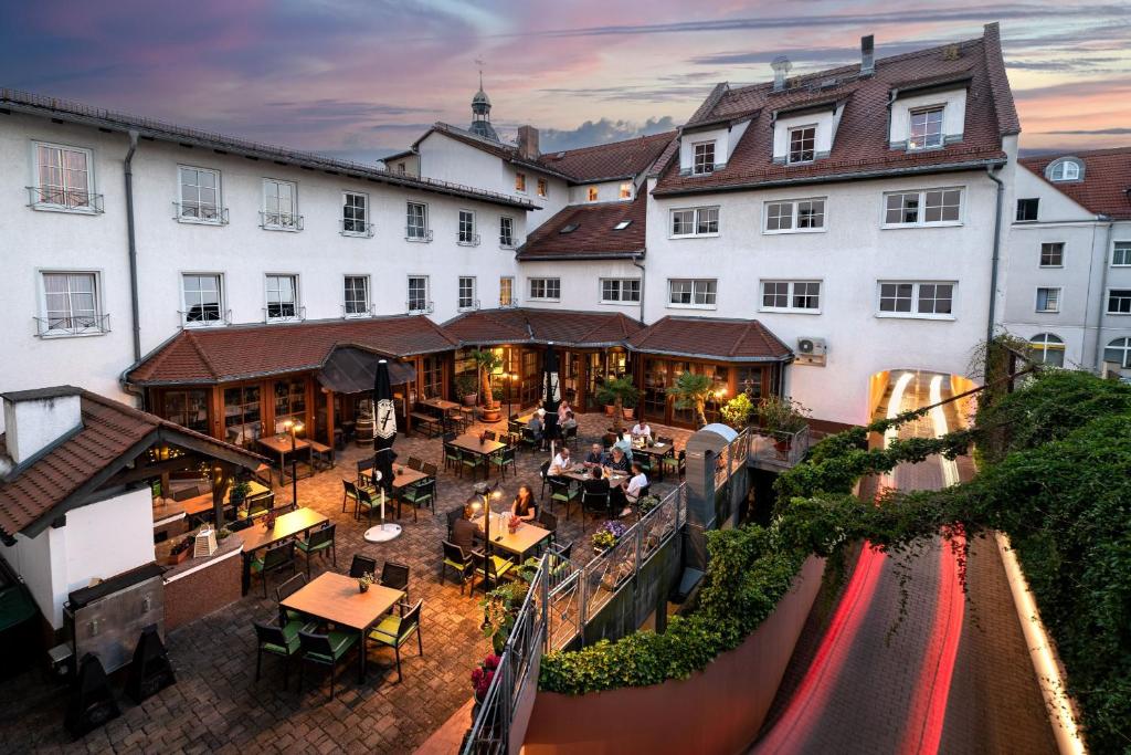 Hotel Reussischer Hof في Schmölln: اطلالة هوائية على مبنى به طاولات وكراسي
