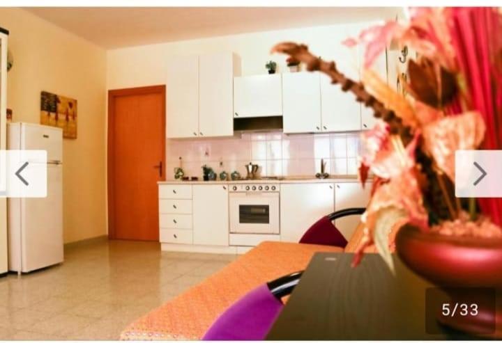 贾迪尼-纳克索斯Casa Vacanze Amici dell' Etna的房间里有白色橱柜和桌子的厨房