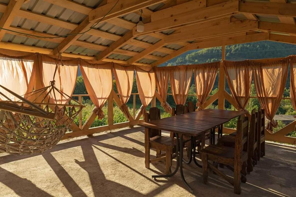 a wooden table and chairs under a pavilion at Guest House end maran ,,vazis saxli,, in Gegelidzeebi