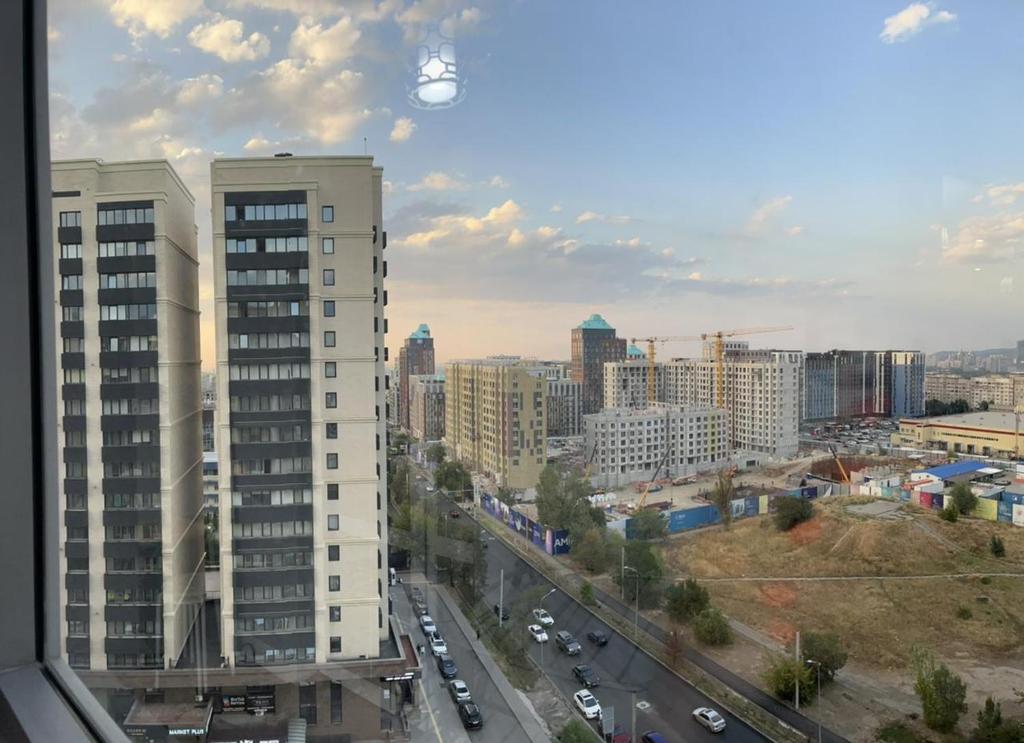 Blick auf eine Stadt mit Gebäuden und Verkehr in der Unterkunft Apartments in the Babylon residential complex in Almaty
