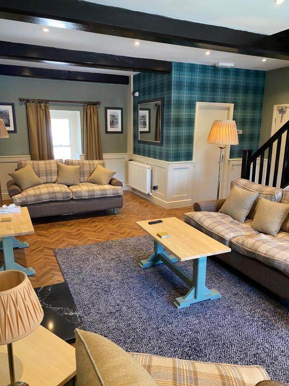 a living room with two couches and a table at Irton Hall in Eskdale