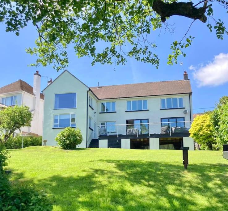 a large white house with a lawn in front of it at Caithness Holiday Home in Pontypool