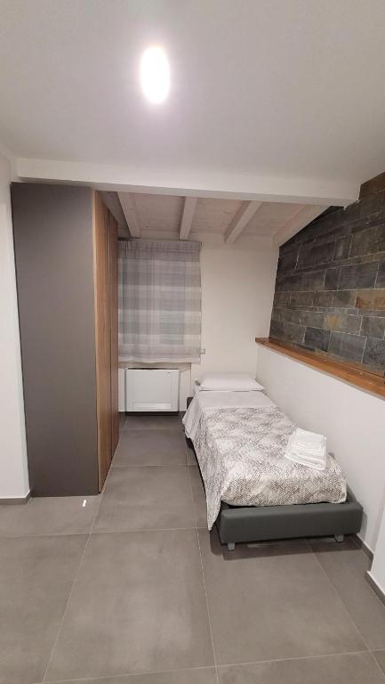 sypialnia z łóżkiem i ceglaną ścianą w obiekcie La Casa Di Nonno Pippo w mieście Milazzo