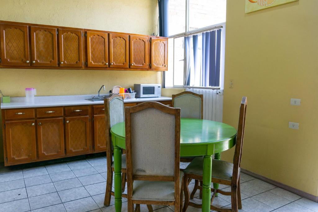una cocina con mesa verde y sillas. en Hotel Colonial, en Aguascalientes
