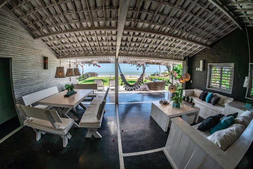 sala de estar con mesa, sillas y piscina en Depraia Beach House - Icaraizinho en Icaraí