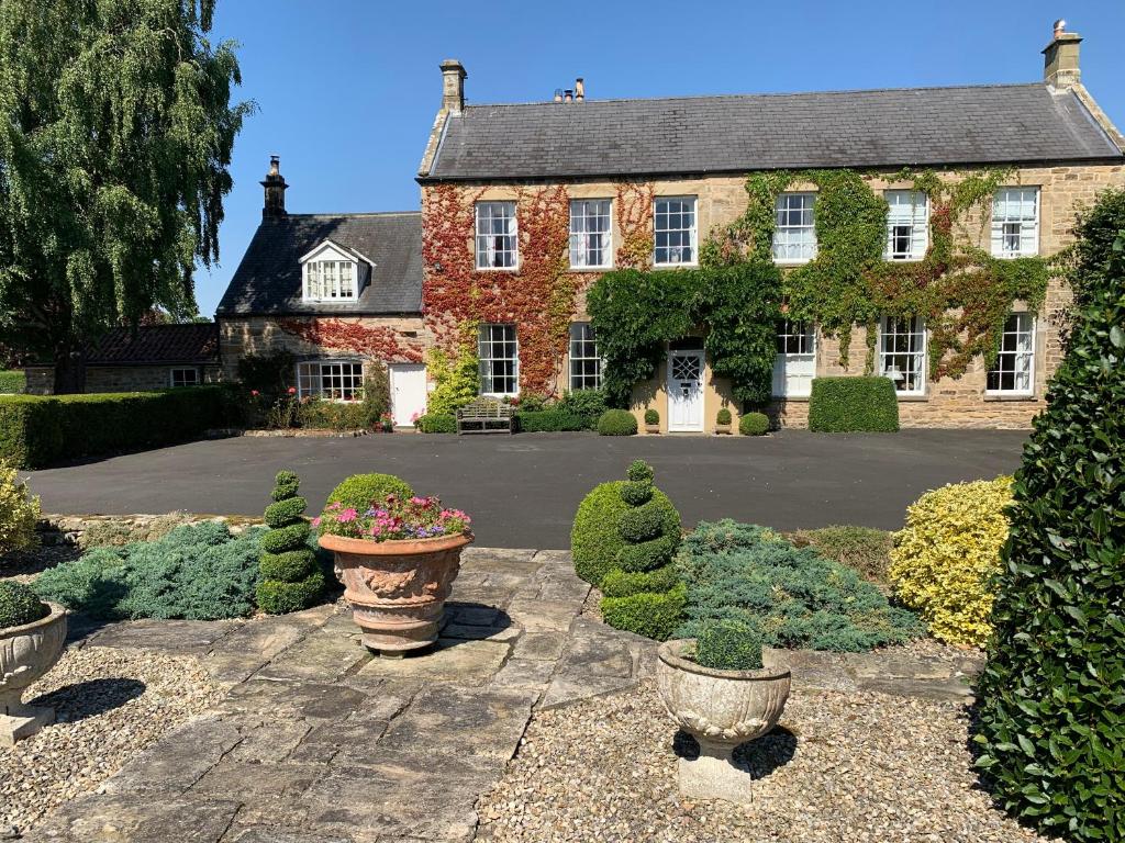a large house with a courtyard with potted plants at Dalton House Bed and Breakfast in Newcastle upon Tyne