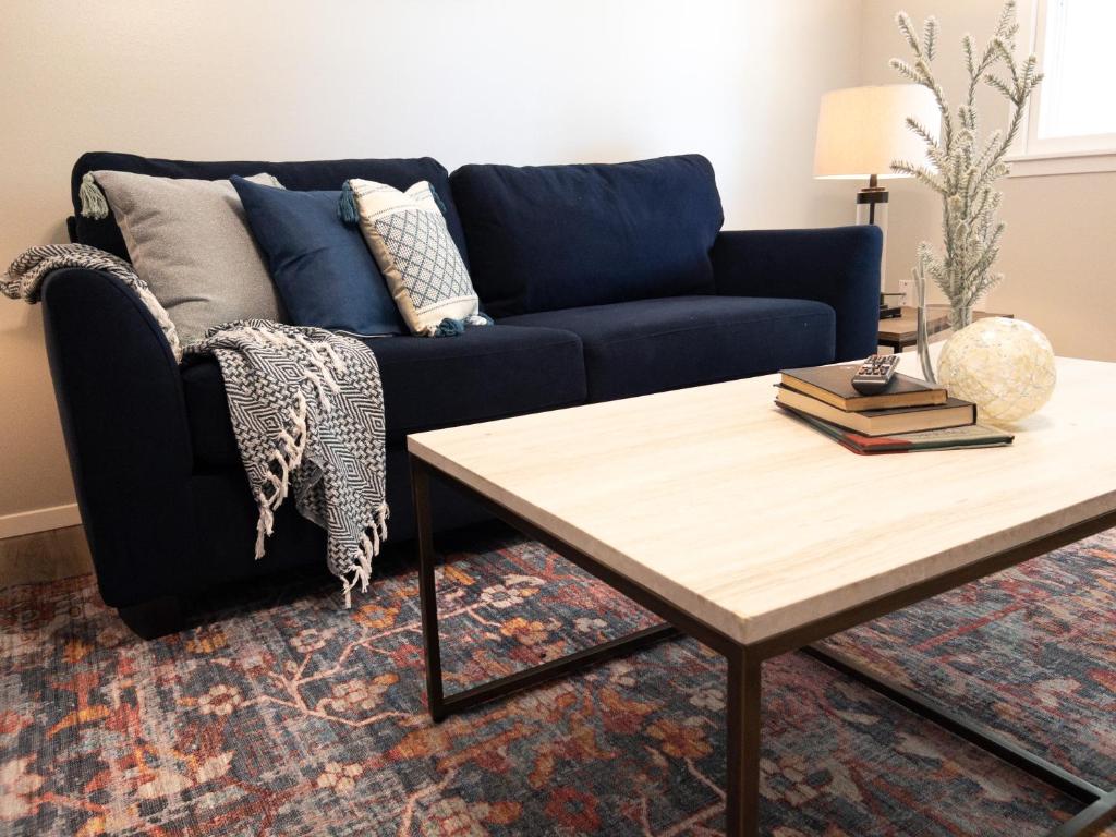 Sala de estar con sofá azul y mesa de centro en Subtle comfort and style in quiet neighborhood., en Joplin