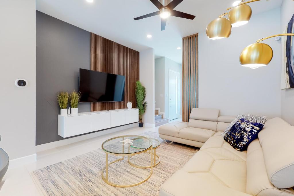 Una sala de estar con un sofá blanco y un televisor. en Dolphin Paradise Unit B, en South Padre Island