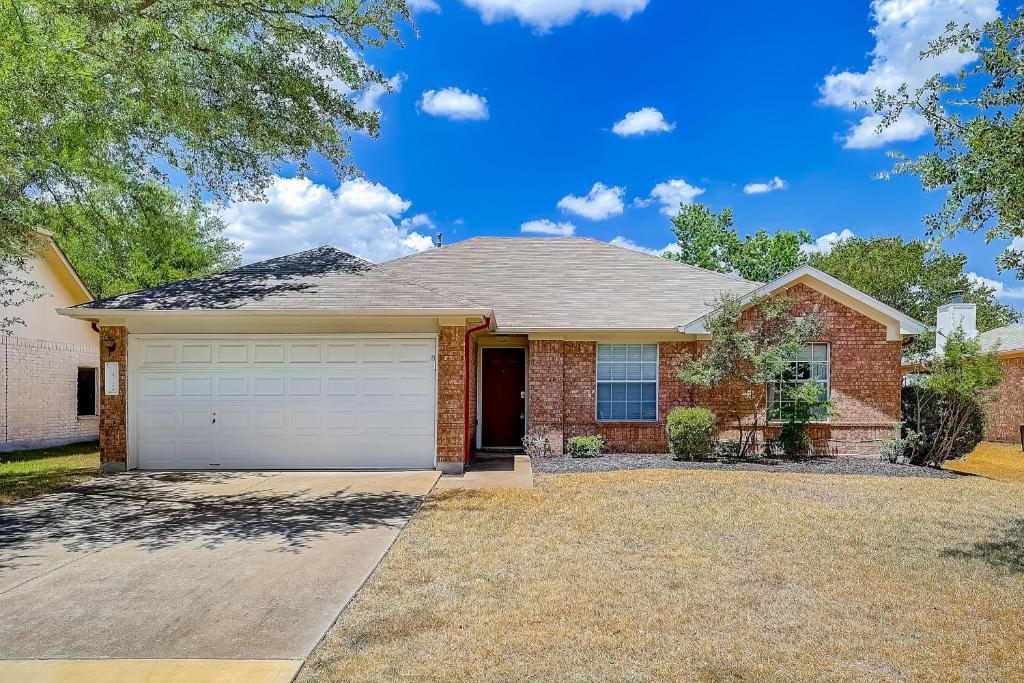 una gran casa de ladrillo con garaje en Brickhouse Retreat en Round Rock