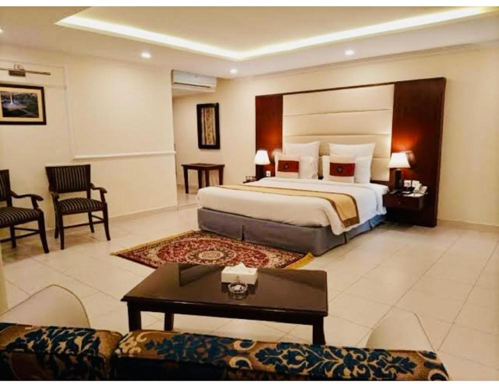 a large hotel room with a bed and a couch at Hotel New Mid City in Multan