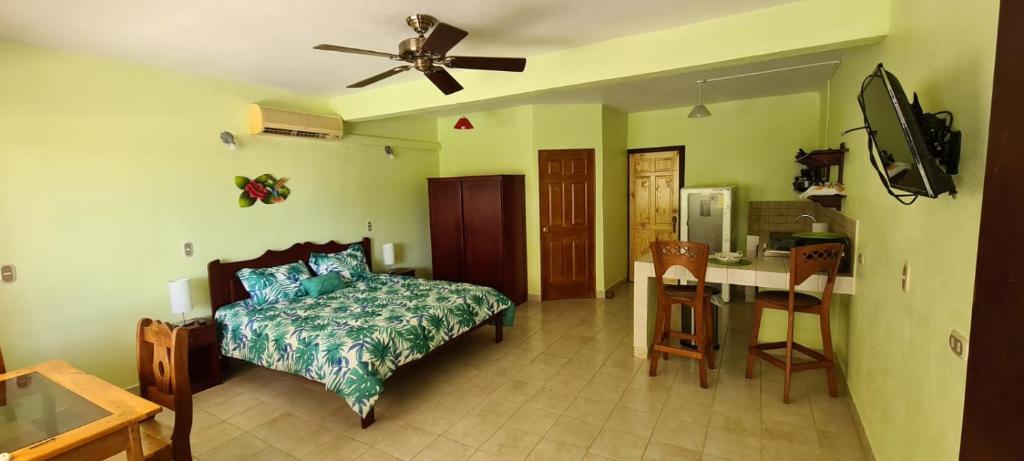 a bedroom with a bed and a table and a ceiling fan at Hermosa Paradise in Playa Hermosa