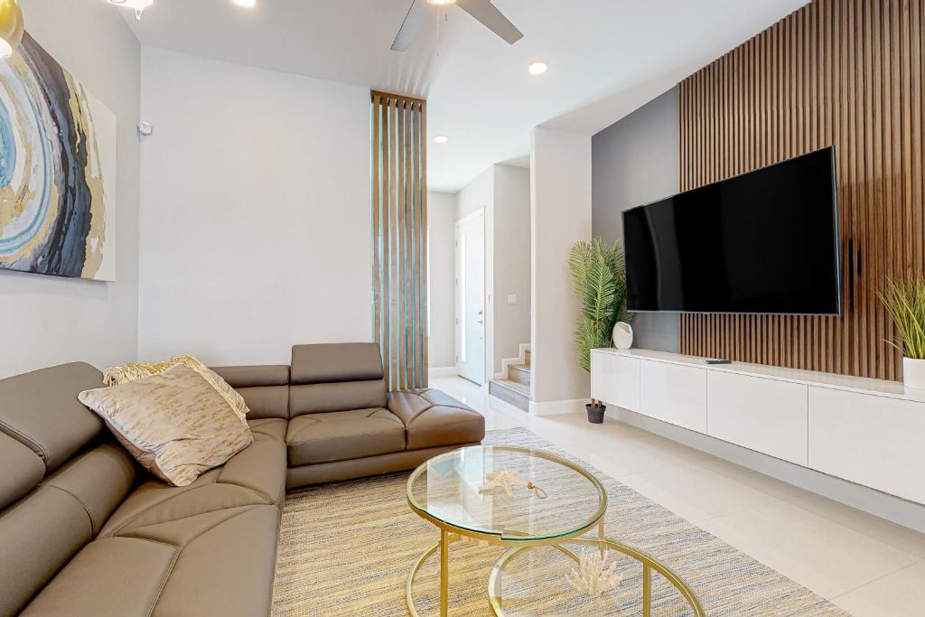 a living room with a couch and a flat screen tv at Dolphin Paradise Unit A in South Padre Island