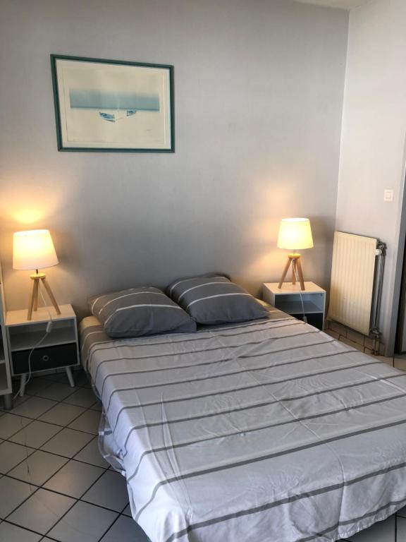 een slaapkamer met een groot bed met 2 lampen bij Green Square Grand Balcon LE LAC et centre ville à pied Annecy in Annecy