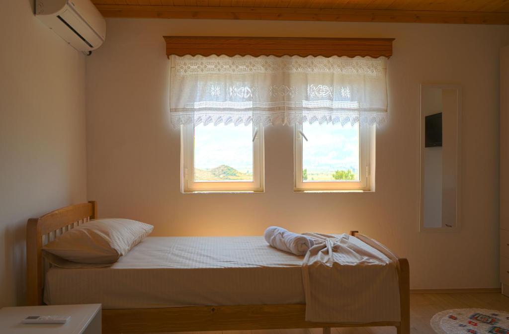 una camera con un letto e una finestra di VILA SHAMETAJ a Gjirokastër