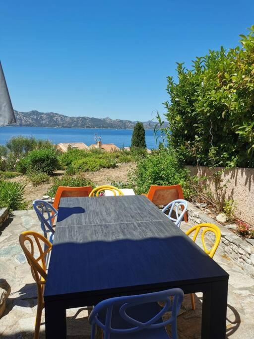 une table et des chaises avec vue sur l'eau dans l'établissement U Mirante, Panoramic terrace over gulf sunset, à Patrimonio