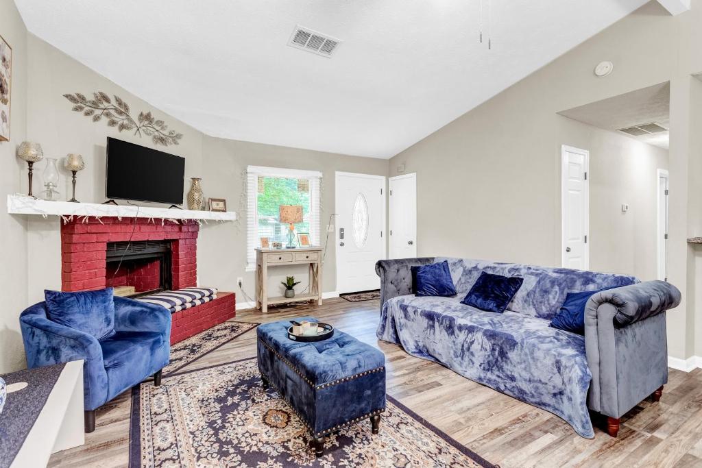 sala de estar con 2 sofás azules y chimenea en Pleasant Stay Getaway, en Atlanta
