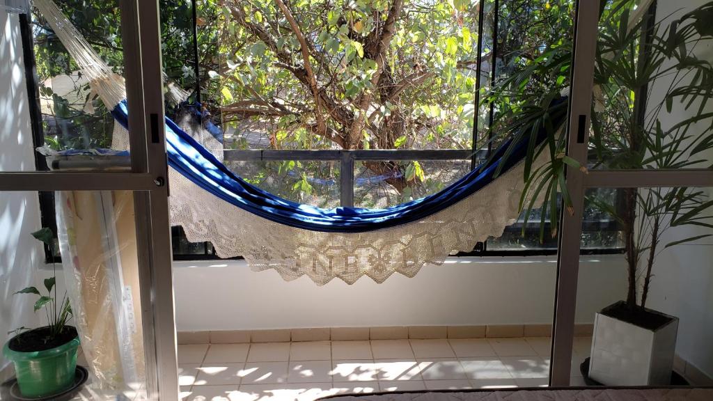 ein Fenster mit einer blauen Hängematte in einem Zimmer in der Unterkunft Descanse na rede da varanda em um local nota 10 e Wi Fi top! in Brasilia