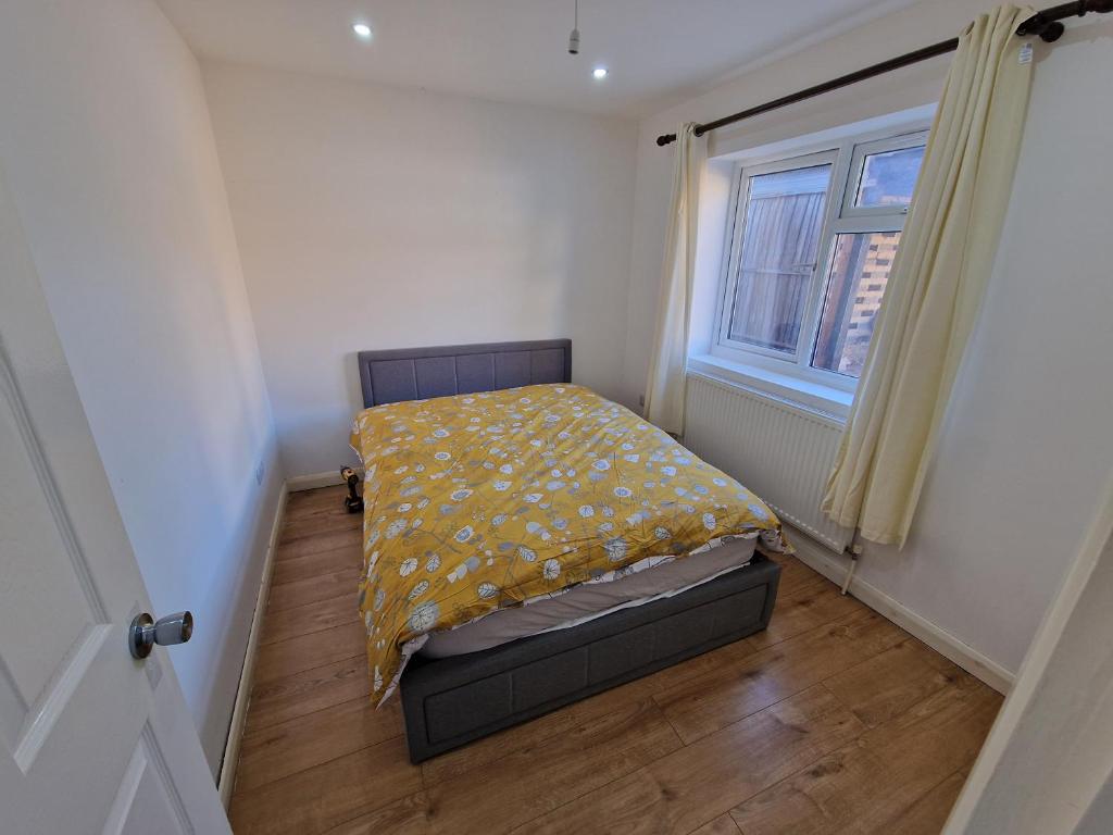 een kleine slaapkamer met een bed en een raam bij Mile End Budget Guesthouse in Londen