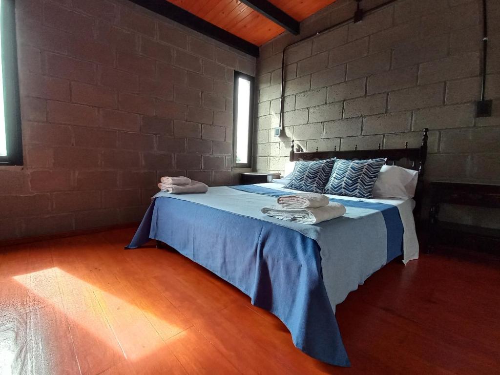 1 dormitorio con 1 cama en una pared de ladrillo en casa de fin de semana en Termas de Río Hondo