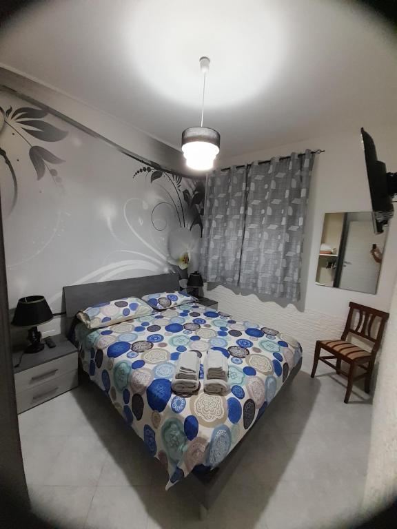 um quarto com uma cama e uma cadeira em Casa Dimora Cavallo em Torre Santa Sabina