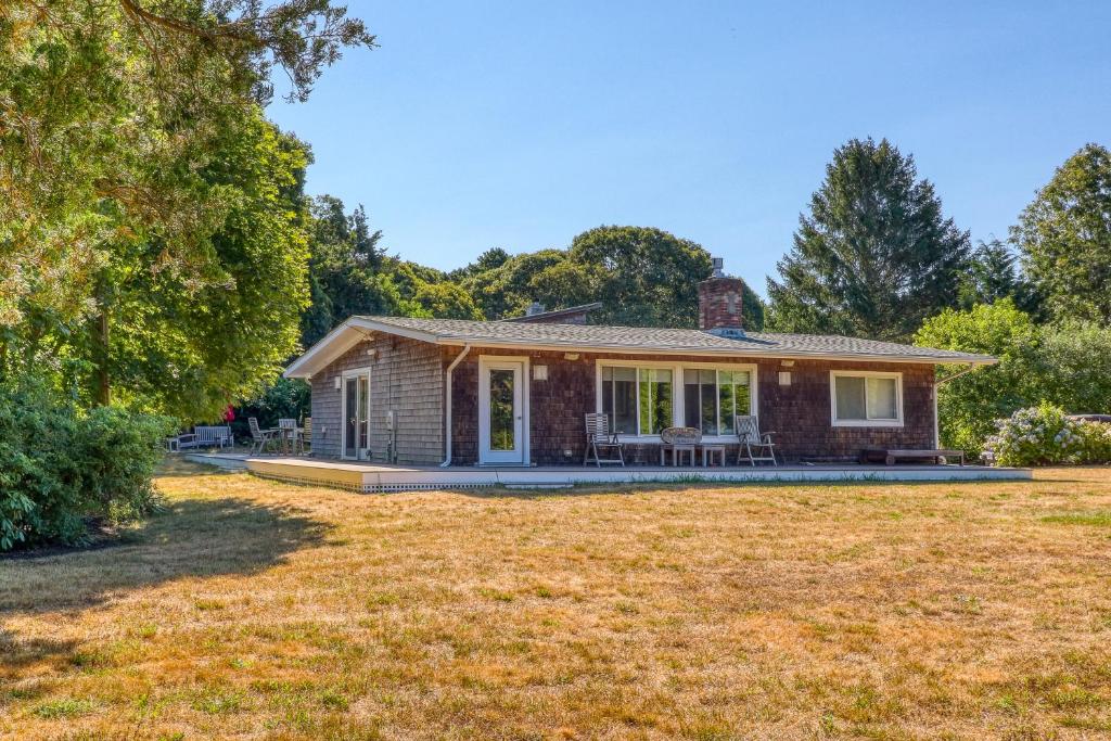 a brick house with a lawn in front of it at Yellow Brick Road House in Oak Bluffs