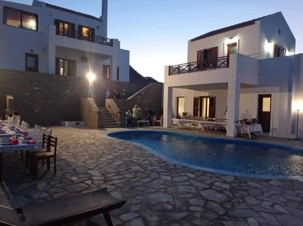 a villa with a swimming pool in front of a house at Villas El Paradiso in Kouroúpi