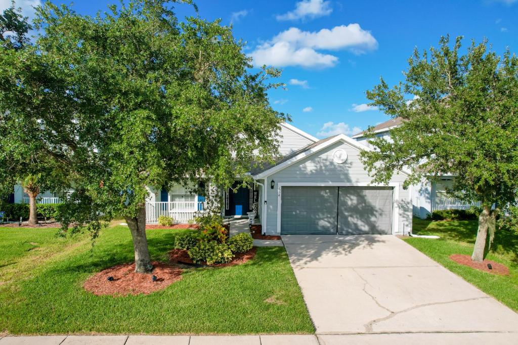a house with a tree and a driveway at Remington View Retreat in Kissimmee