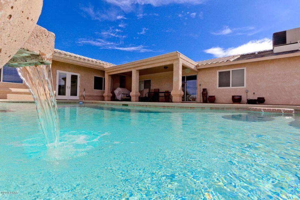 uma piscina com uma fonte em frente a uma casa em PRIVATE VIEW ON THE LAKE SIDE OF 95! Sleeps 16 em Lake Havasu City