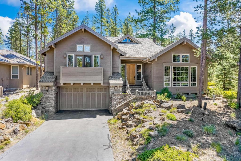 a home in the woods with a driveway at Luxury on Lassen in Sunriver
