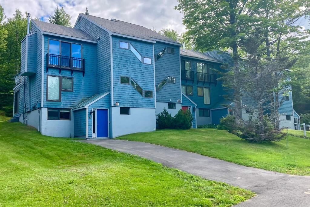 ein großes blaues Haus mit einem grünen Hof in der Unterkunft Sugarloaf Mountain Treasure in Carrabassett