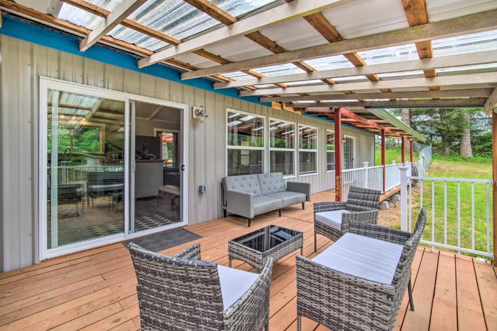 a patio with chairs and a couch on a deck at Cozy North Bend Getaway Near Dunes and Ocean! in Lakeside