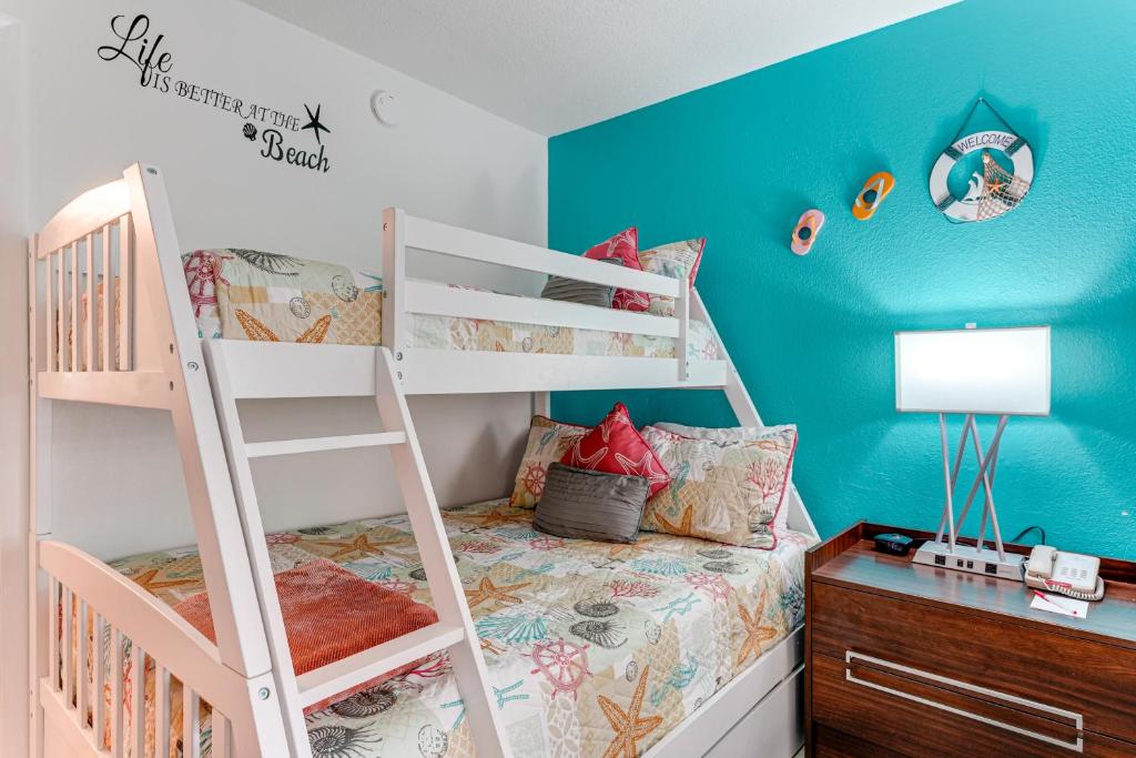 a bedroom with two bunk beds and a desk at Sarasota Cay Club #612 - Heated Pool, Bunk Beds, Huge TV, Tiki Bar, More! in Sarasota