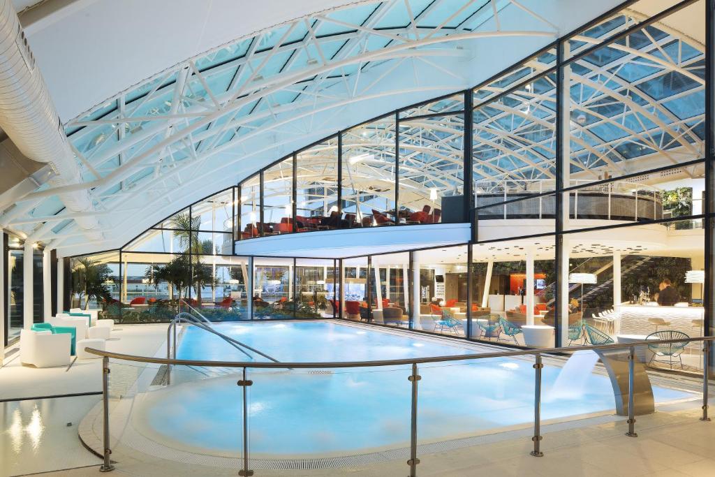 a large building with a glass ceiling at Oceania Paris Roissy CDG in Le Mesnil-Amelot