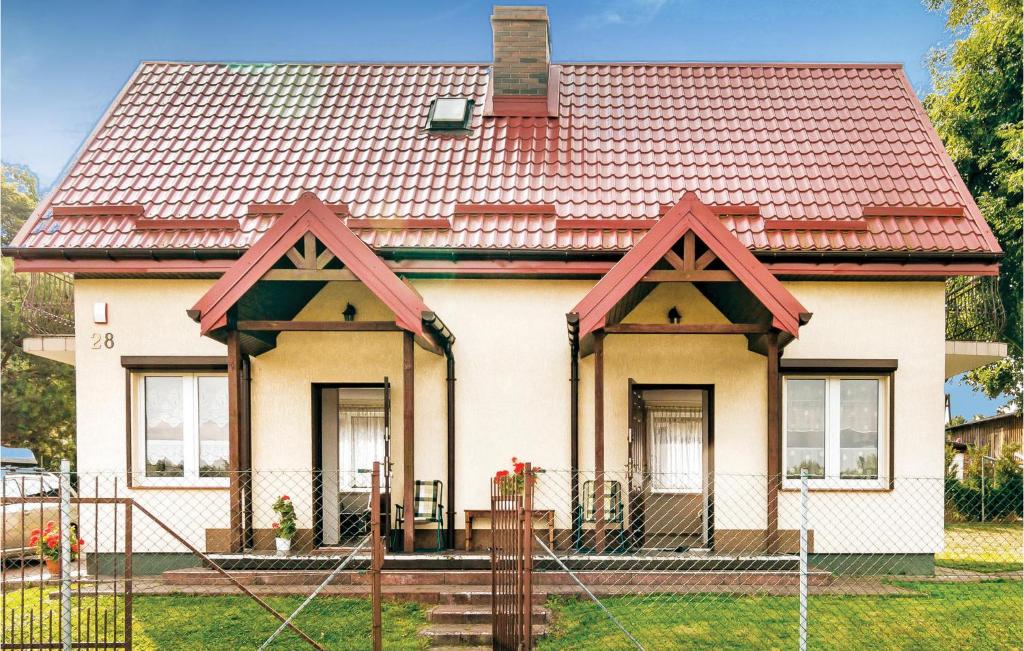 ein kleines weißes Haus mit einem roten Dach in der Unterkunft Holiday Home Mielno Akacjowa in Mielno