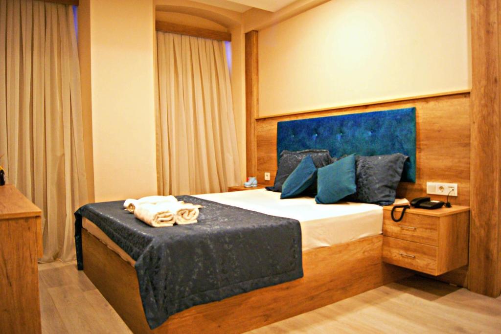 a bedroom with a bed with a blue head board at Destinia Pera Suites in Istanbul