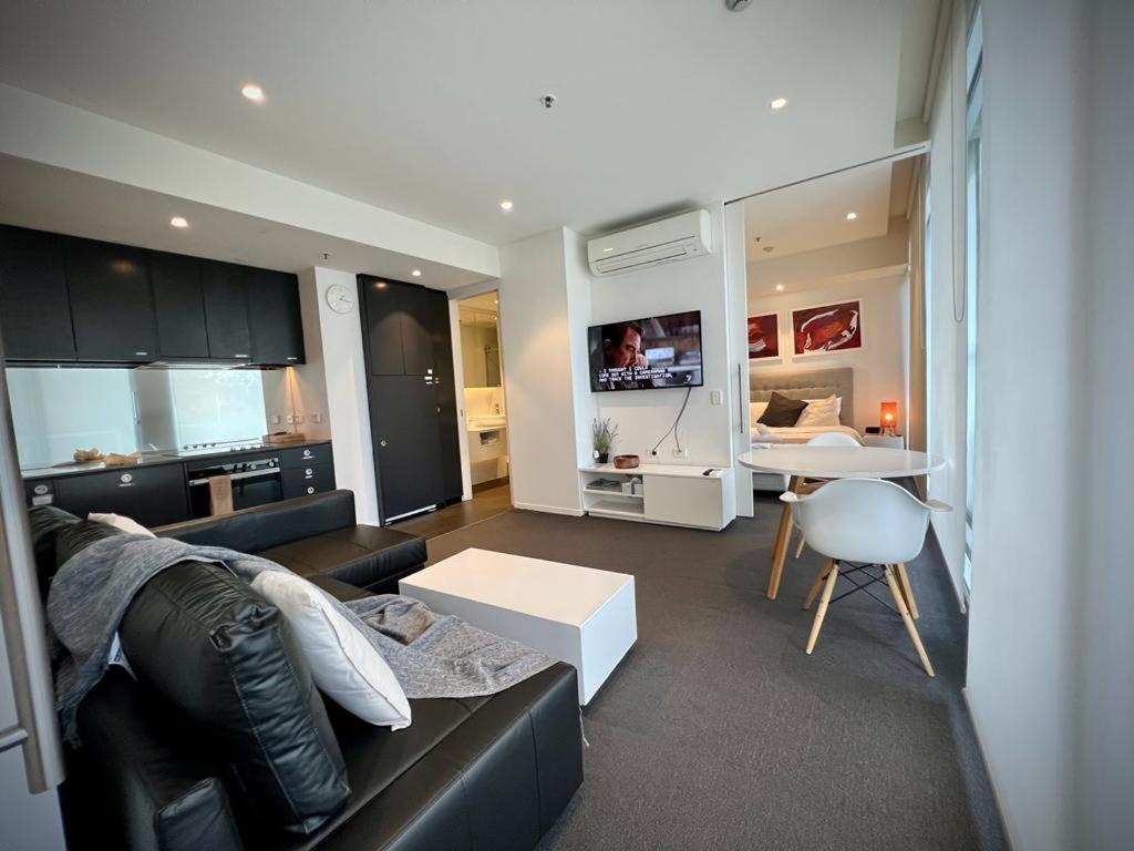 - un salon avec un canapé noir et une table blanche dans l'établissement Luxury 2 Bedroom Suite near Adelaide with a car park, à Broadview