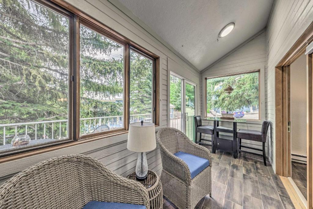 a screened in porch with wicker chairs and a table at Dreamy, Family-Friendly Cloudcroft Townhome! in Cloudcroft