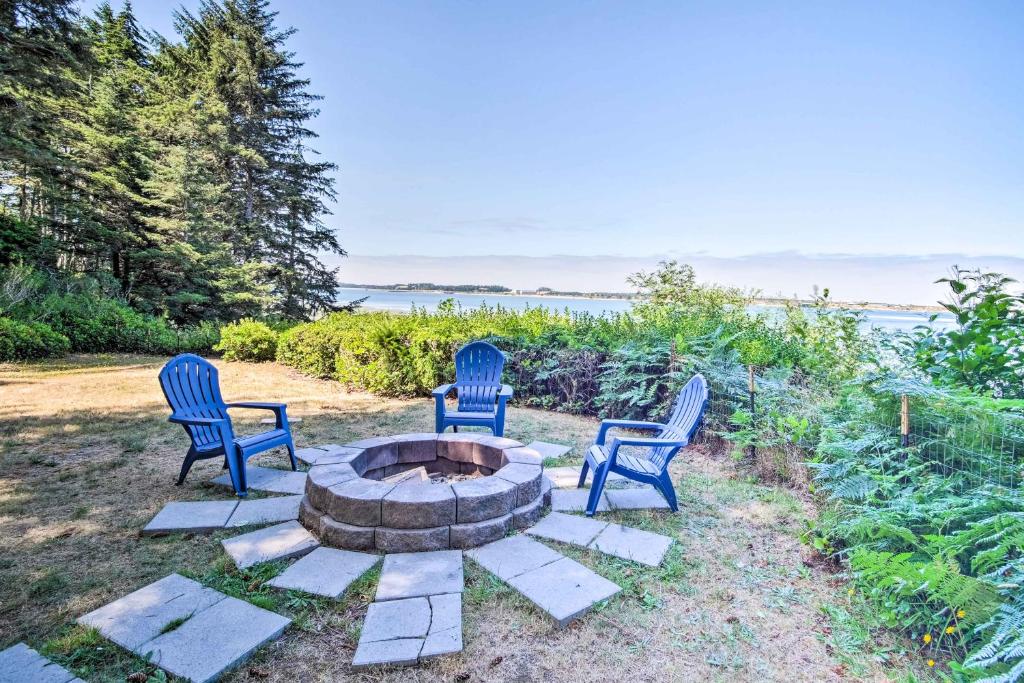 a group of three chairs sitting around a fire pit at Enchanting Coos Bay Sanctuary with Lush Views! in Coos Bay