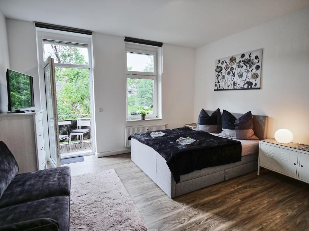 a bedroom with a bed and a couch and a tv at Appartement OTTO I - Erfurt Zentrum in Erfurt