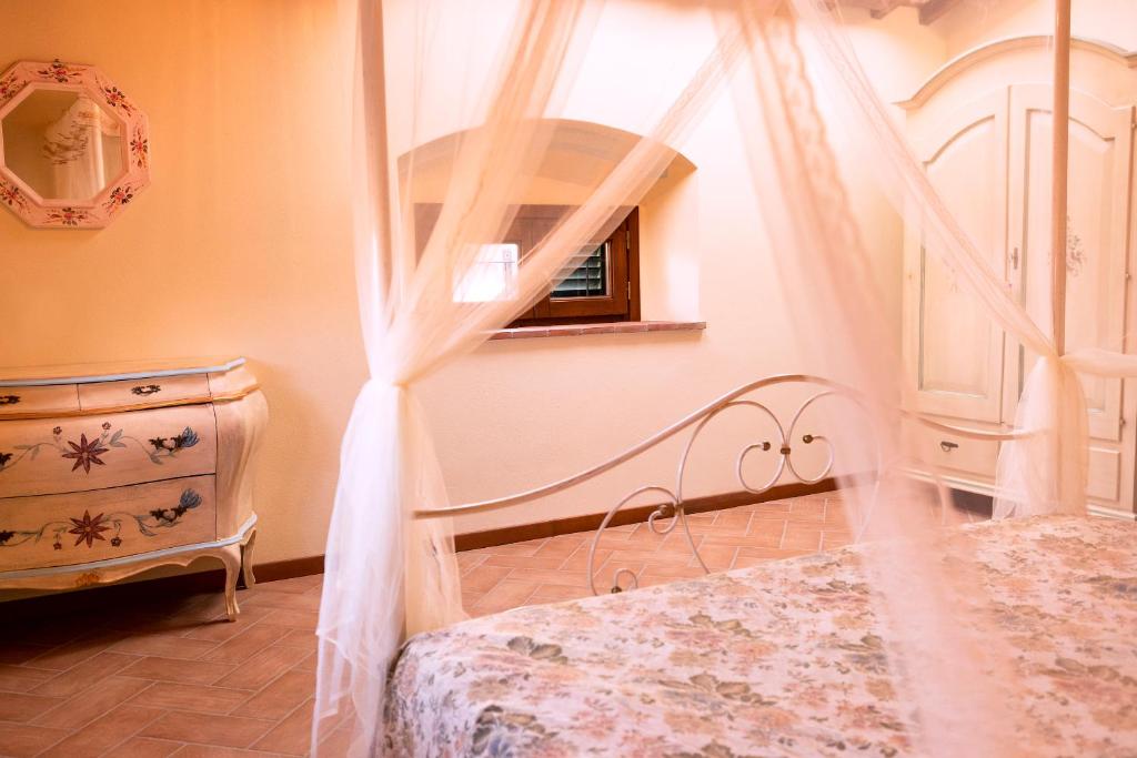 a bedroom with a bed with a canopy and a dresser at Casa alle Monache in Gambassi Terme