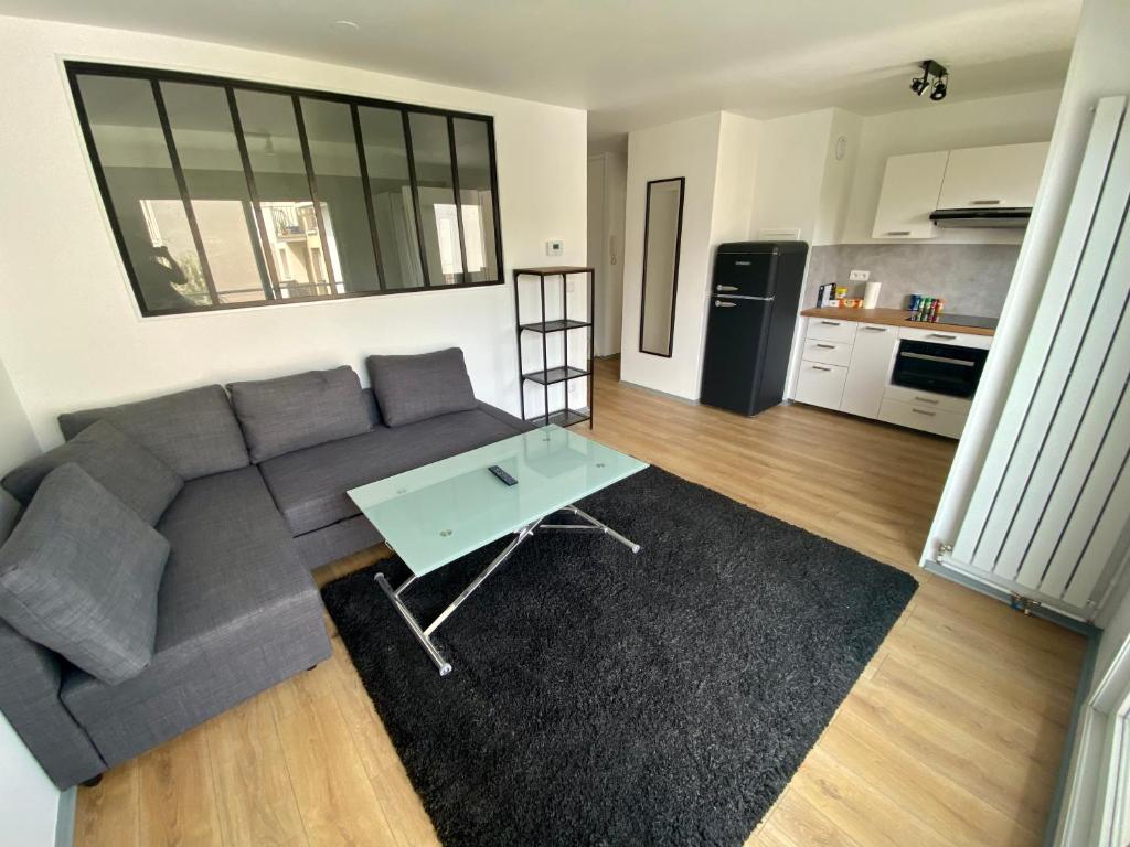 a living room with a couch and a table at Le cœur de Rive gauche - Superbe T3 - parking - 082 in Rouen